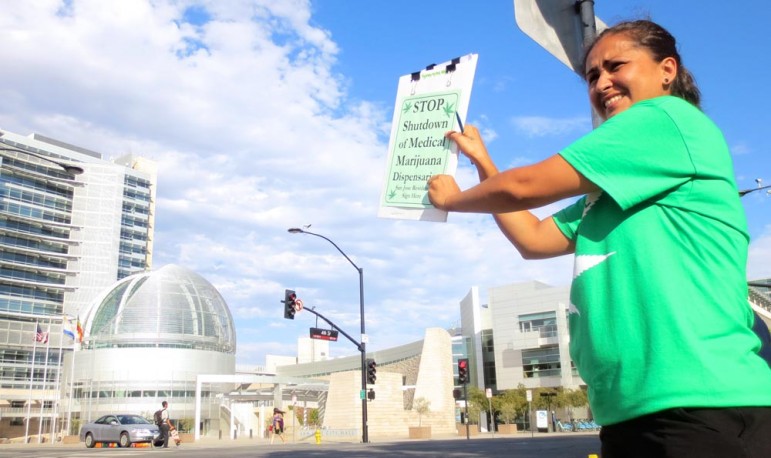 Anita Inocencio, whose mom relied on edibles to ease the pain during chemotherapy for lung cancer, stands across from City Hall trying to drum up signatures for a referendum.