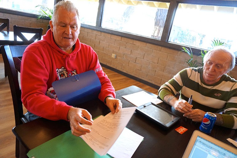 Oak Crest residents Alan Hinman and JJ Vogle sort through records they say show how badly the park fell into disrepair. (Photo by Jennifer Wadsworth)