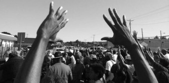Protests across the nation have brought attention to how unarmed African-American men are being targeted by law enforcement. Many have used the phrase "hands up, don't shoot" as a rallying cry. (Photo by Trymaine Lee, via Twitter)