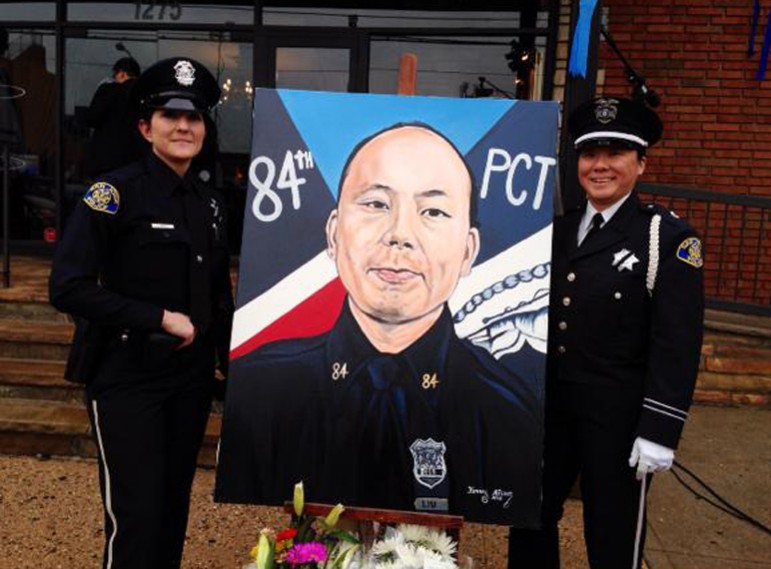 San Jose police officer Wakana Okuma, right, poses with an image of slain New York City officer Wenjian Liu at a funeral in January. SJPD Chief Larry Esquivel posted the image to his Twitter account. (Photo via Twitter)