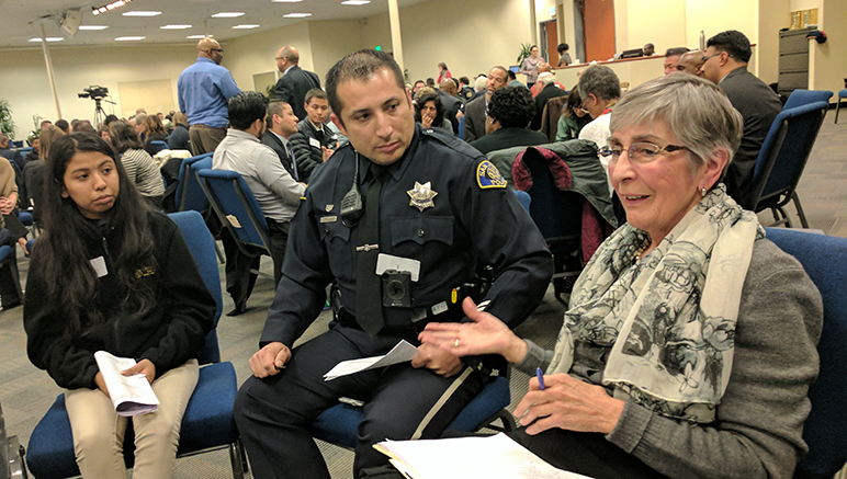 Officer Jose Montoya (center) listens as Carmen Johnson (right) talks about a negative interaction she had with a San Jose cop. (Photo by Jennifer Wadsworth)