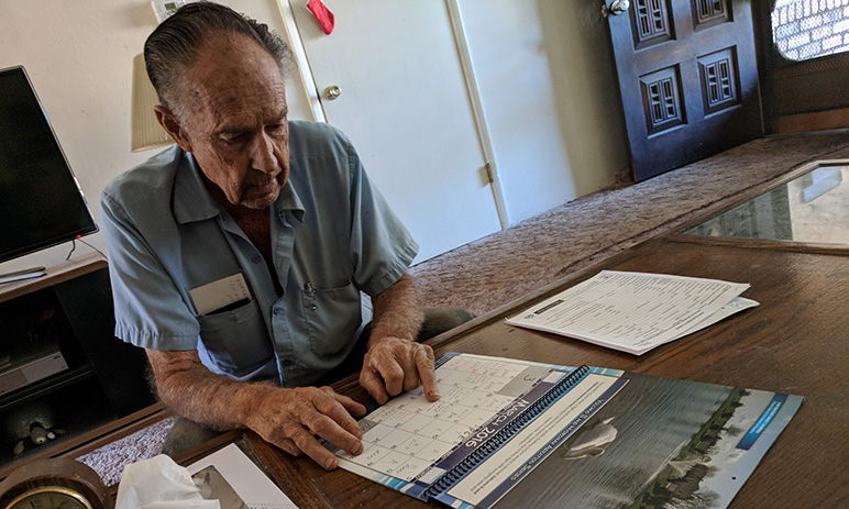Dick Kavanagh reviews his calendar, where he marked dates he witnessed construction work on the next-door unit. (Photo by Jennifer Wadsworth)