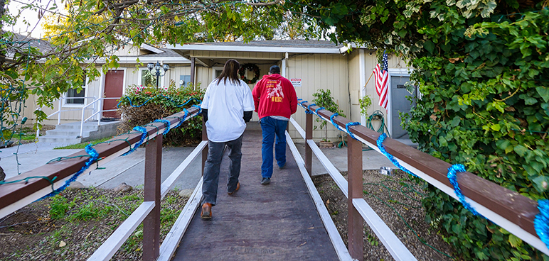 Richard Franko and counselor Joaquin Aguirre (left to right) walk up the ramp to Life Choices, a former drug treatment facility that has since become an unlicensed sober living home. (Photo by Greg Ramar)