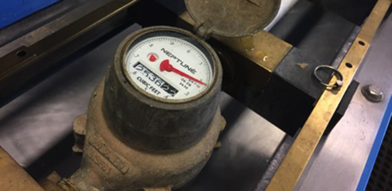 A Neptune T-10 water meter gets placed into a test bench at San Jose Water’s meter shop on Bascom Avenue. Almost all of the company’s residential customers have this type of meter. (Photo by Camille Miller)